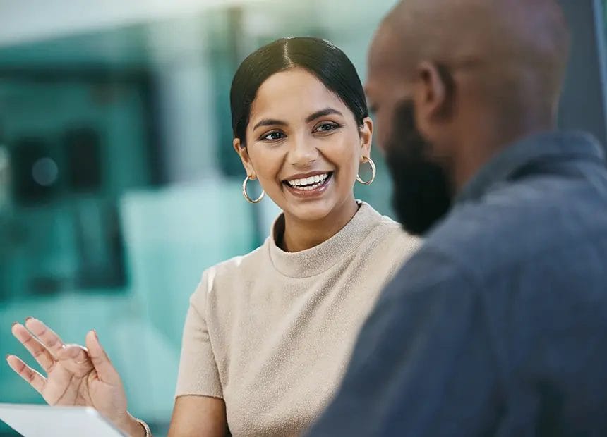 Lady smiling, looking at a man within an office